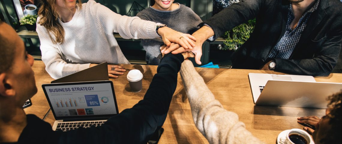 Team members joining hands in unison