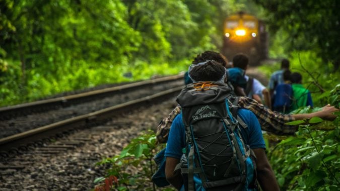 A group of people walking together next to a train track