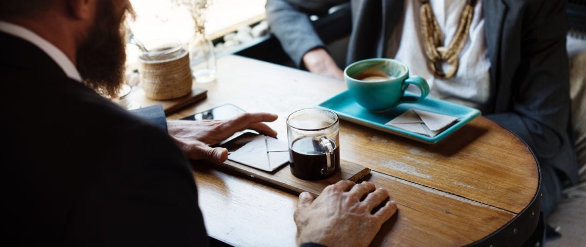 A man and woman meet over coffee