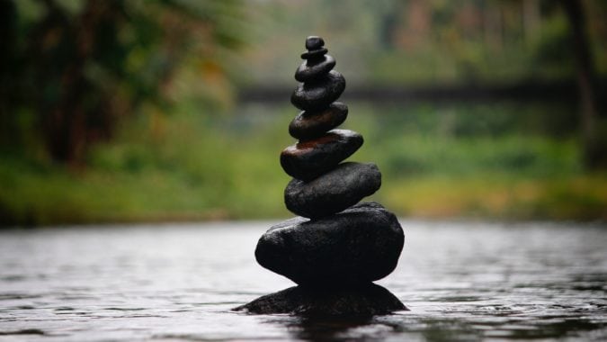 Eight small rocks are balanced one on top of the next